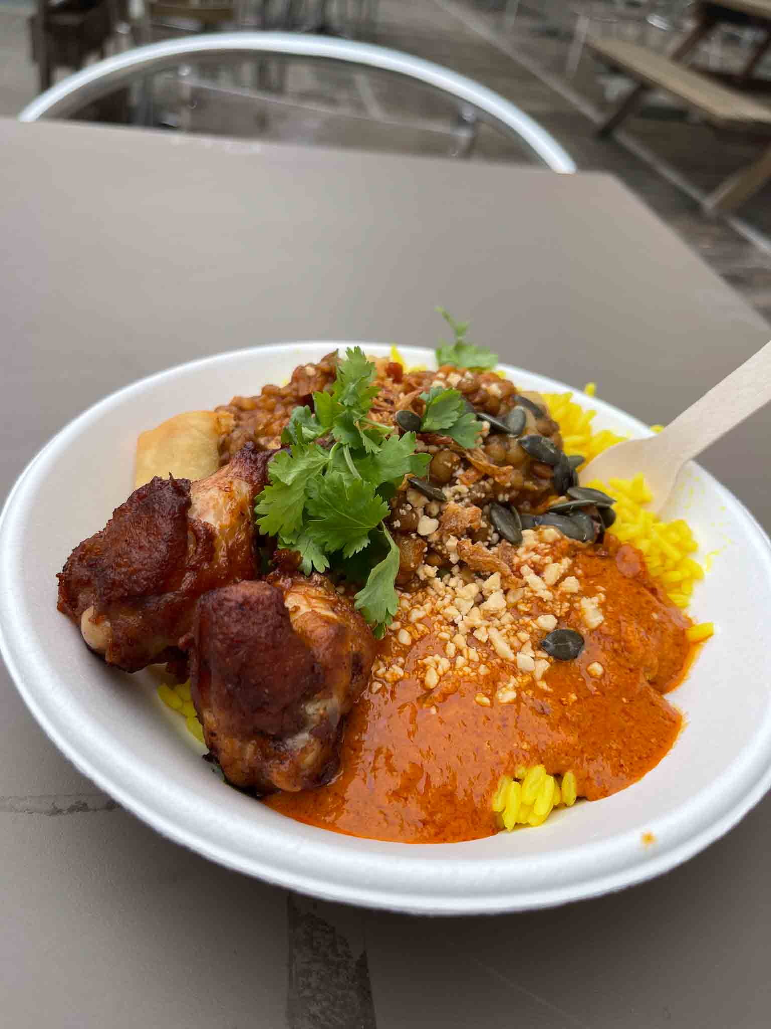 Een wit bord met Tajine met lamsvlees, abrikozen en couscous.